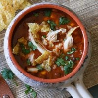 Easy Chicken Tortilla Soup in a tustic bowl with a handle on a cutting board