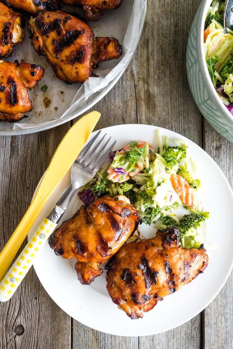 A plate of honey siracha grilled chicken with salad.