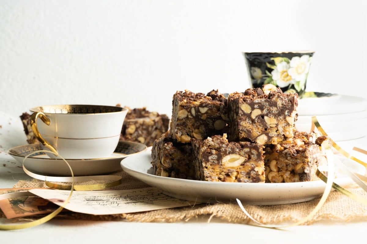 peanut butter chocolate rice krispie bars on a plate with some tea cups.