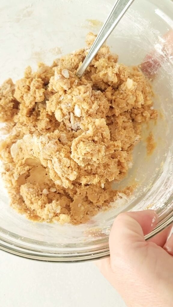 A recipe for peanut butter balls with rice krispies in a large bowl.
