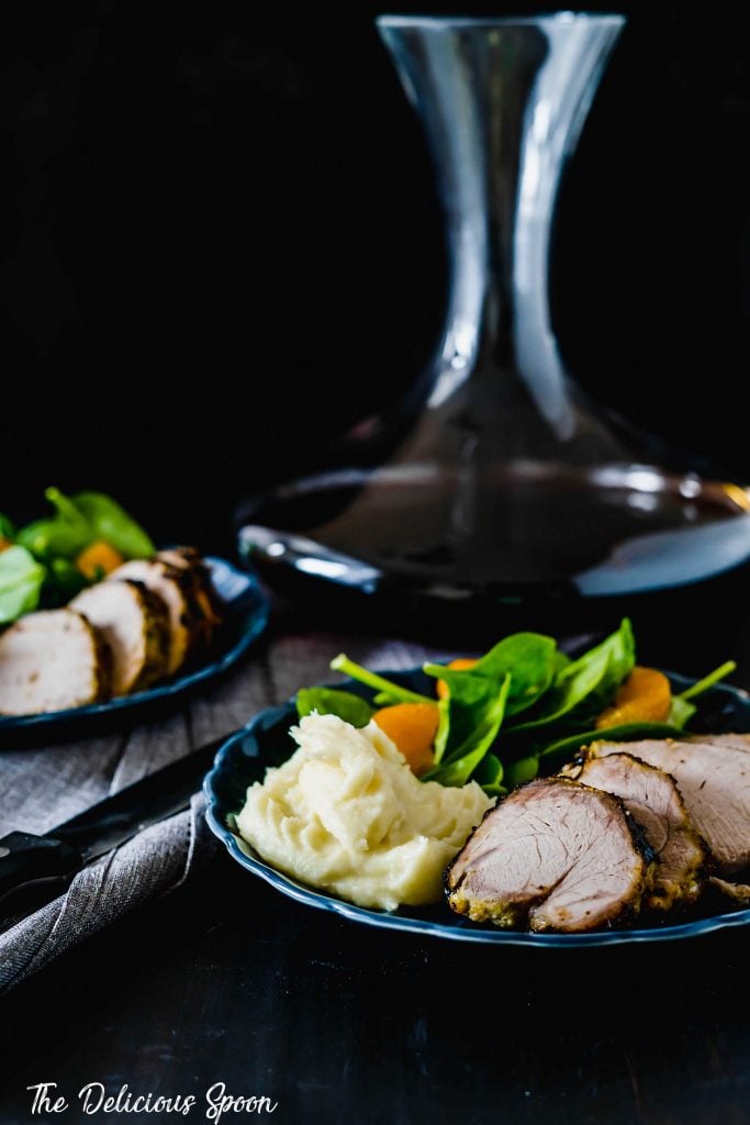 Two dinner plates featuring cuban style baked port tenderloin with a fresh salad and pureed parsnips