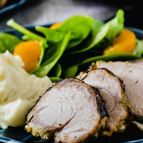Close up of a mojo pork tenderloin recipe with salad and potatoes