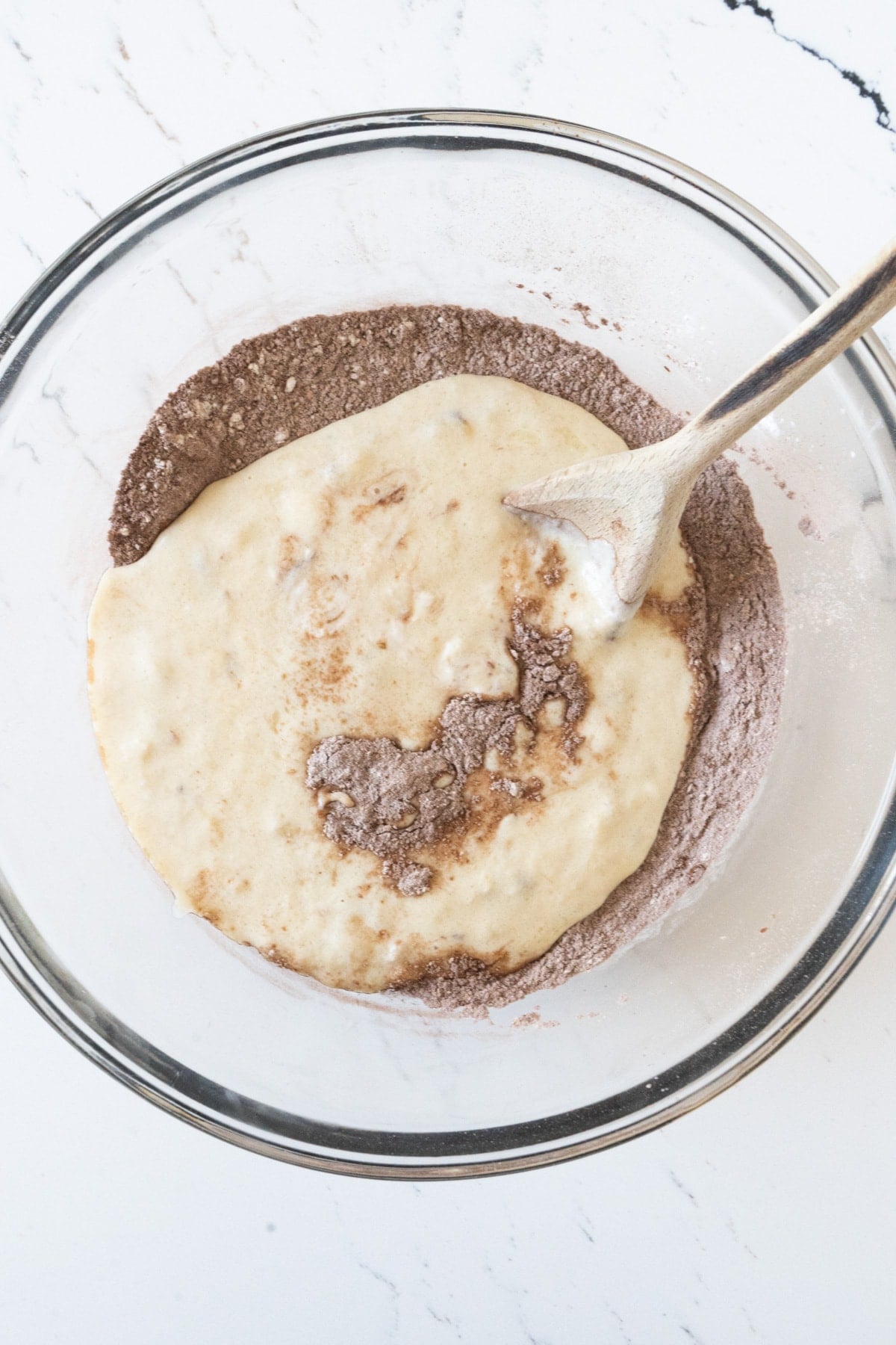 A bowl of flour, cocoa and a mashed banana mixture.