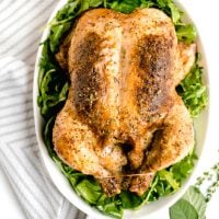 Whole Roasted Chicken with Dijon Herb Butter in a white serving bowl