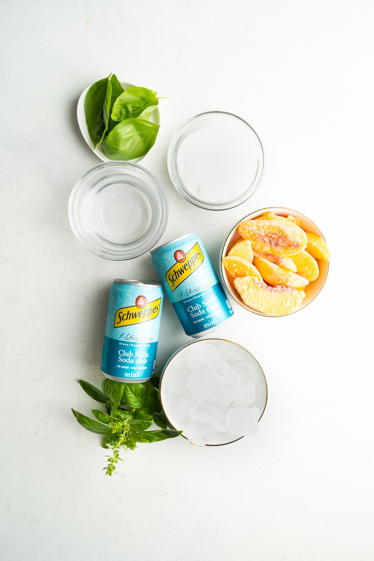 Ingredients for a peach cocktail or mocktail made with peaches, basil and club soda.