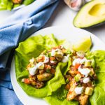 Two plates of Baja Fish Tacos on white plates with a blue napkin