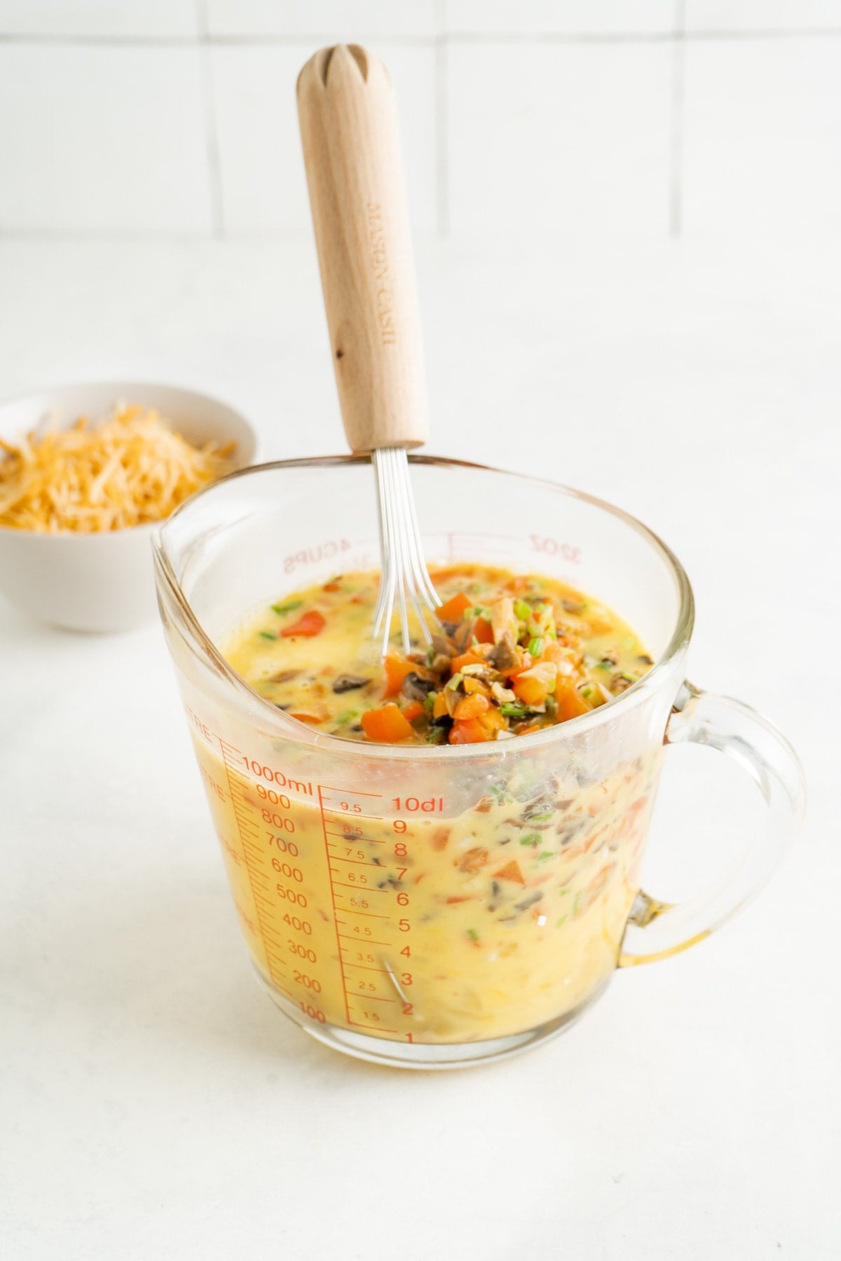 Denver Breakfast Bites egg mixture in a bowl being whisked.