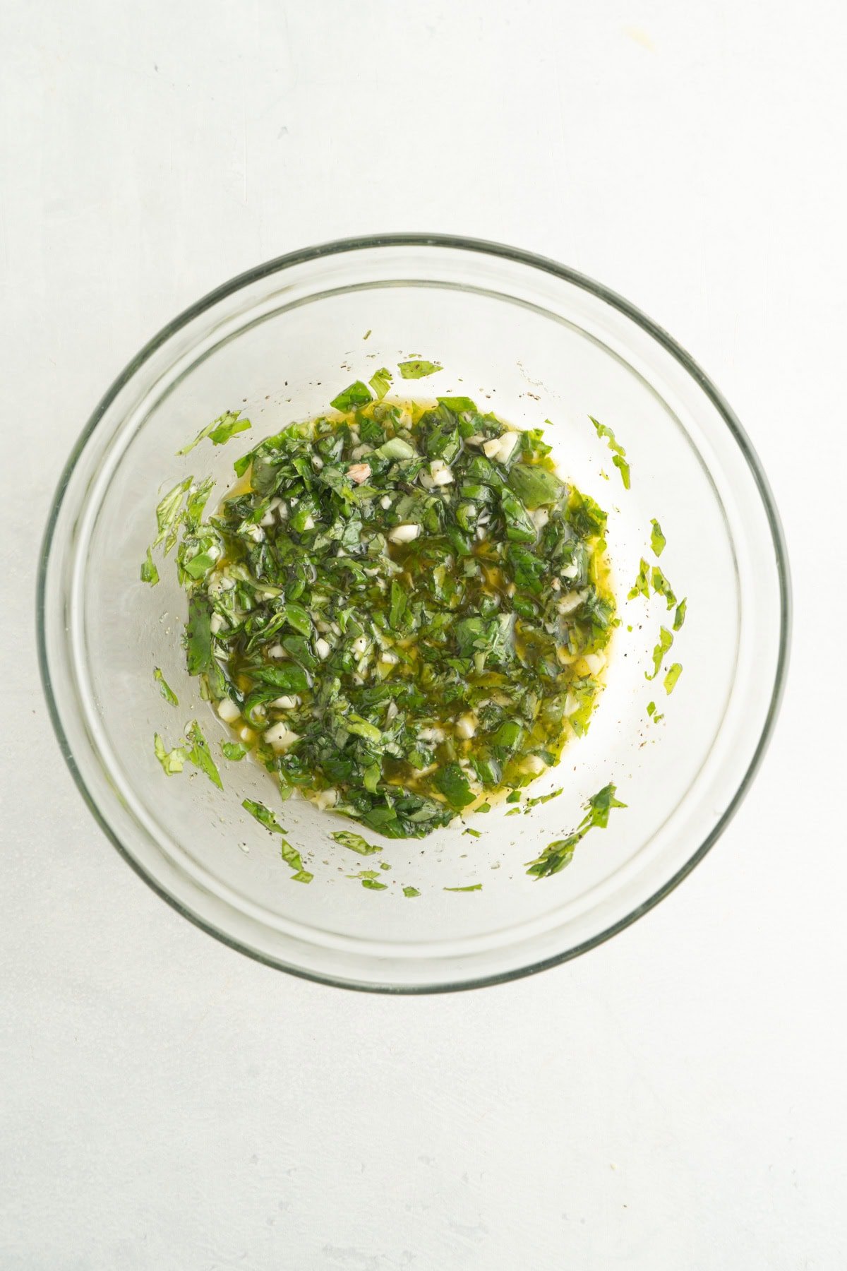 Ingredients for a lemon and basil marinade in a bowl.