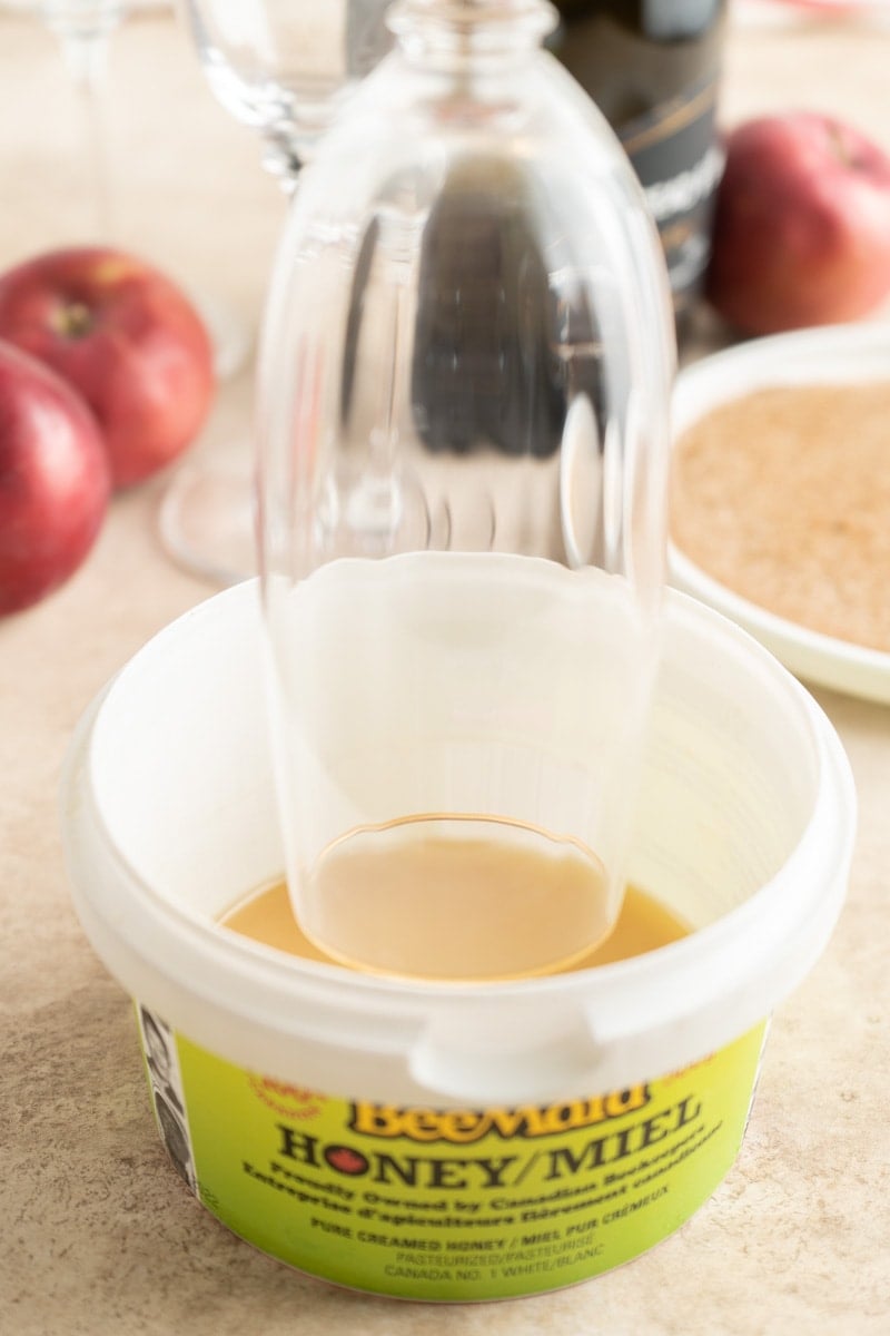 Rimming a champagne flute with honey.