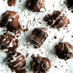 No Bake Oreo Balls on a baking sheet drizzled with icing.