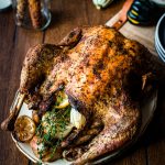 Pic of a roasted turkey with lemons, onions and time and some fall themed decorations