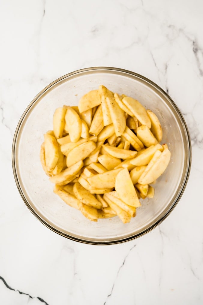 Overhead shot of a bowl of apples that have been tossed in honey and cinnamon