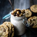 A jar of overnight oats topped with oatmeal cookie crumble with oatmeal cookies around