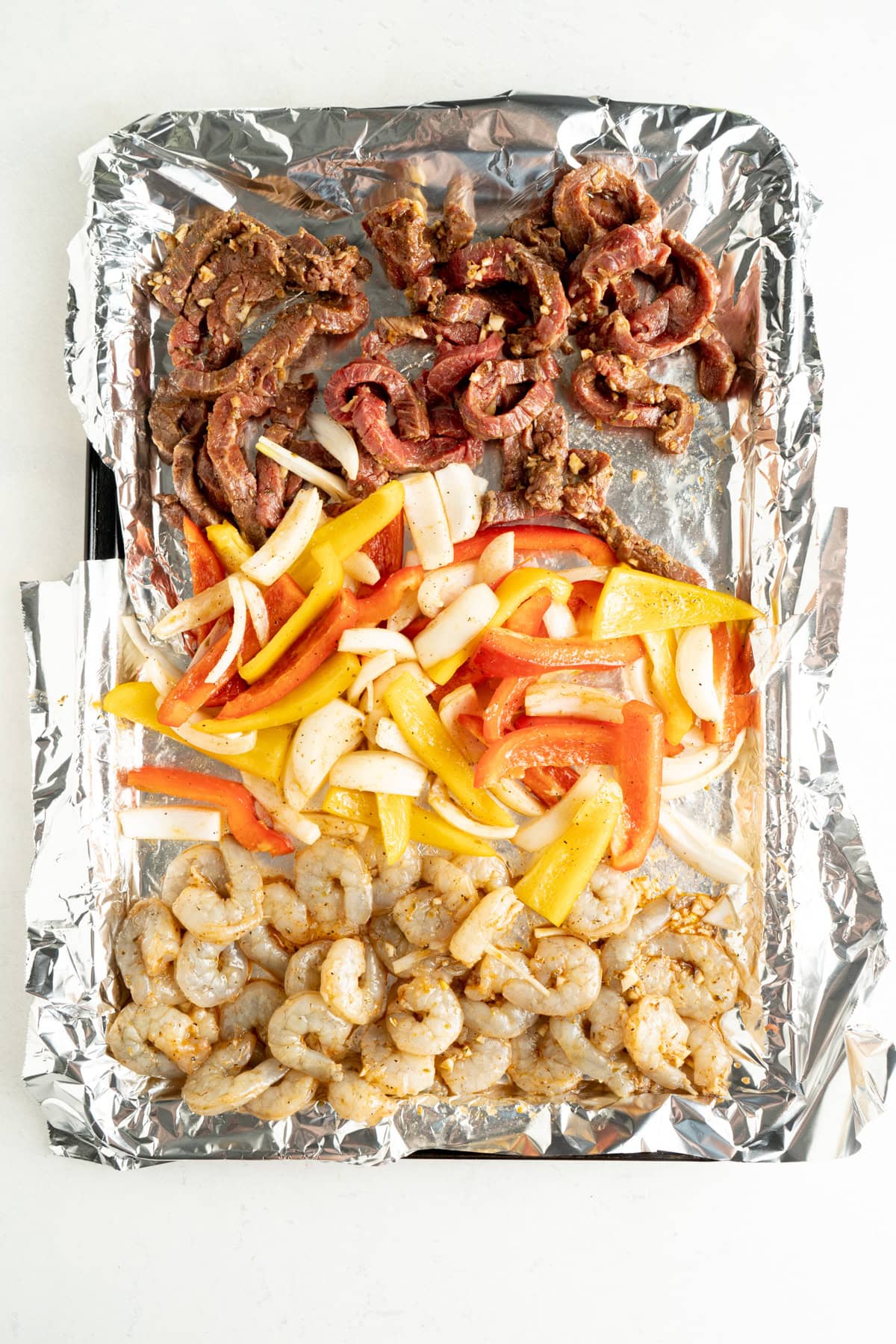 Flank steak fajitas recipe on a baking sheet lined in foil.