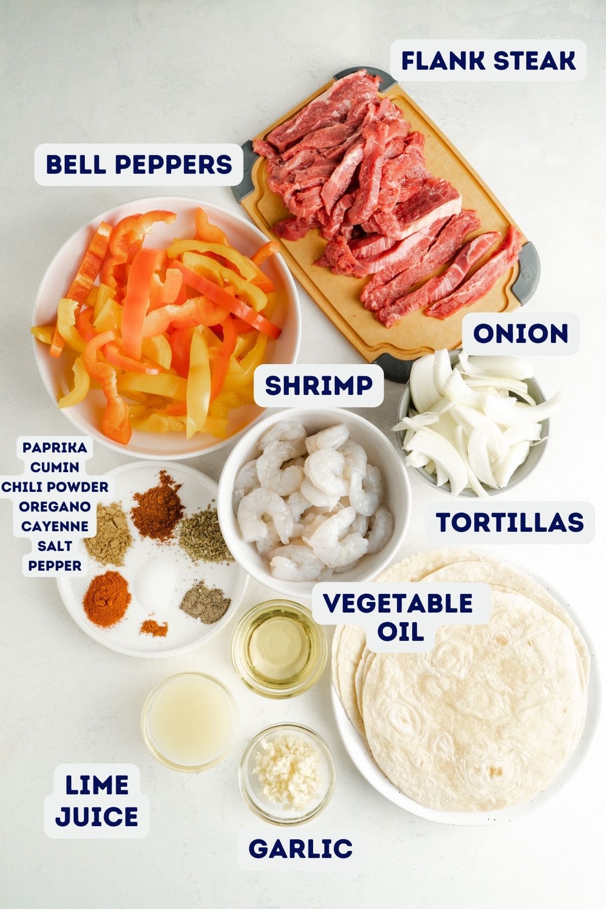 Ingredients for a recipe for steak fajitas and shrimp fajitas made on a sheet pan.