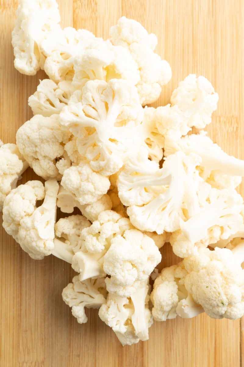Cauliflower florets on a cutting board.
