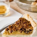 A slice of southern pecan pie on a white plate