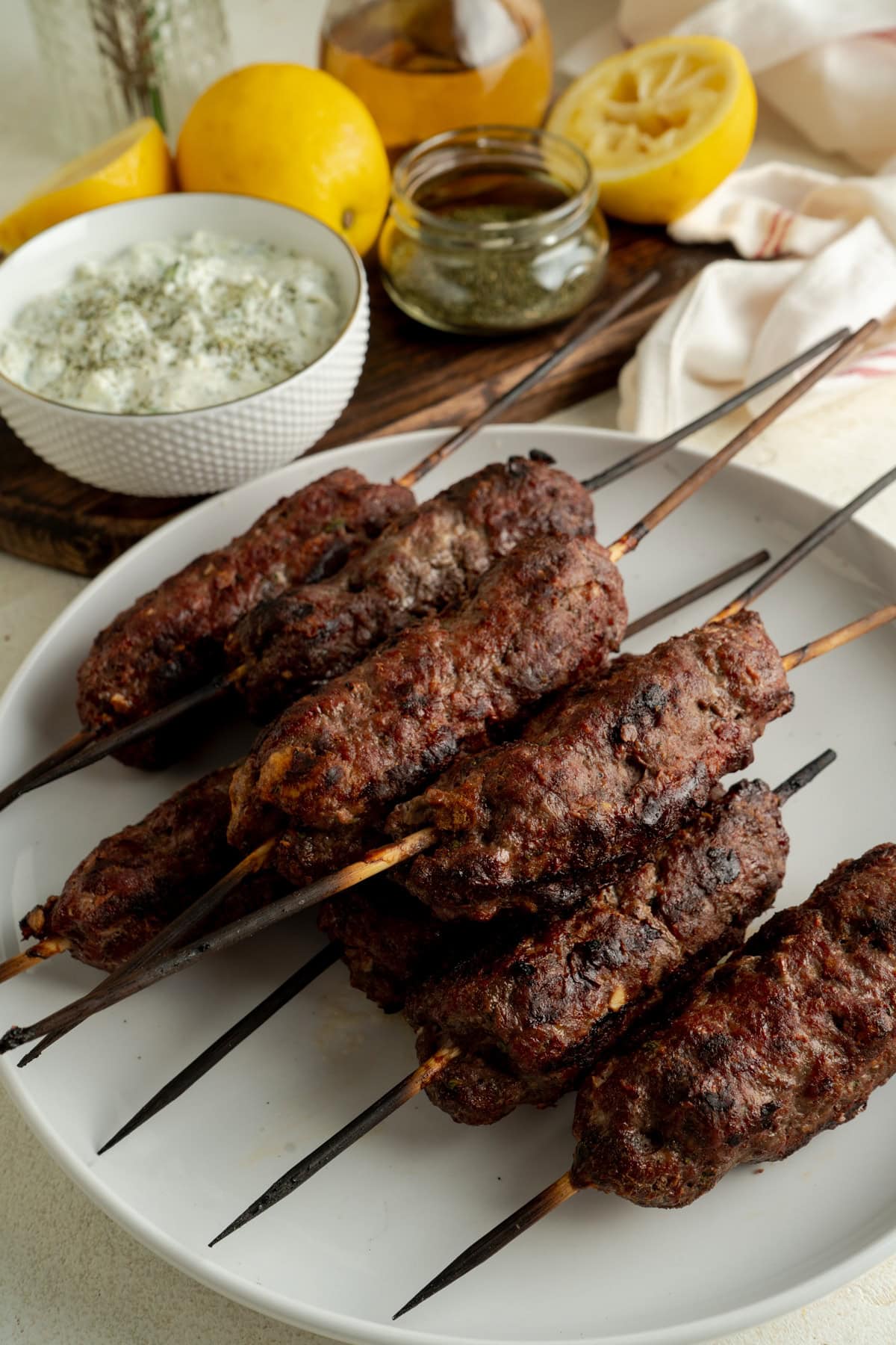A plate of beef kofta skewers on a table.