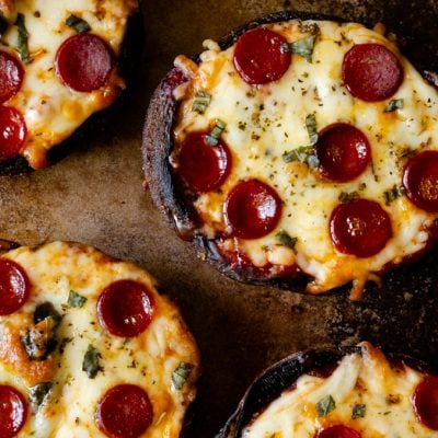Baked portobello stuffed mushroom pizzas on a baking sheet
