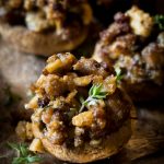 Keto stuffed mushrooms on a silver platter decorated with fresh thyme.