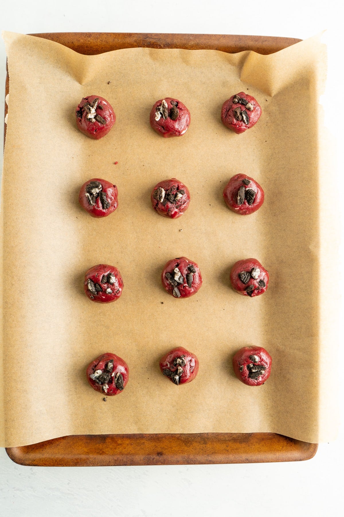 Unbaked cake mix red velvet cookies on a cookie sheet.