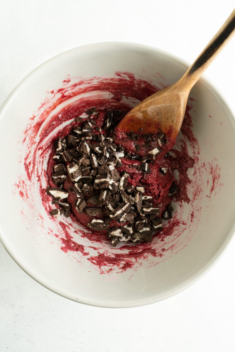 A bowl or red velvet cookies from a cake mix with crushed Oreos added.