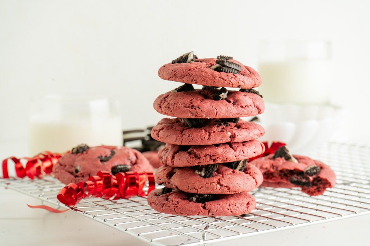 A stack of Oreo Red Velvet Cookies From A Cake Mix on a cooling rack with red ribbon.