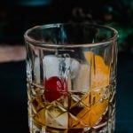 An old-fashioned cocktail on a black background
