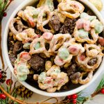 A bowl of Reindeer Chow with Christmas tree branches as decoration