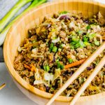 A large bamboo bowl filled with an egg roll in a bowl recipe.