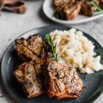 A plate of mashed potatoes and grilled lamb.