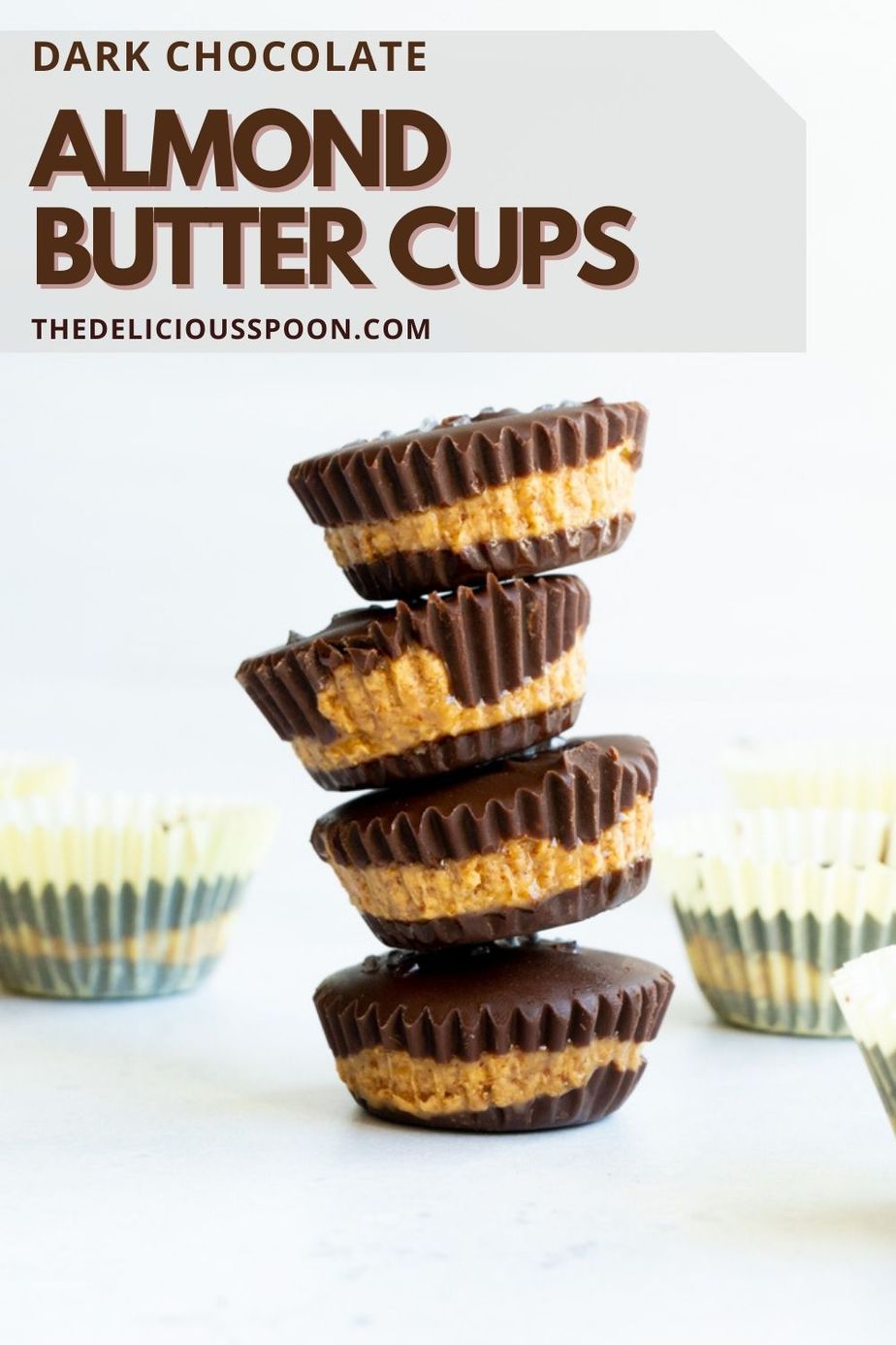 A pinterest pin showing a tower of almond butter cups made with dark chocolate