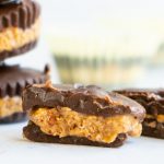 An bite taken out of an almond butter cup made with dark chocolate