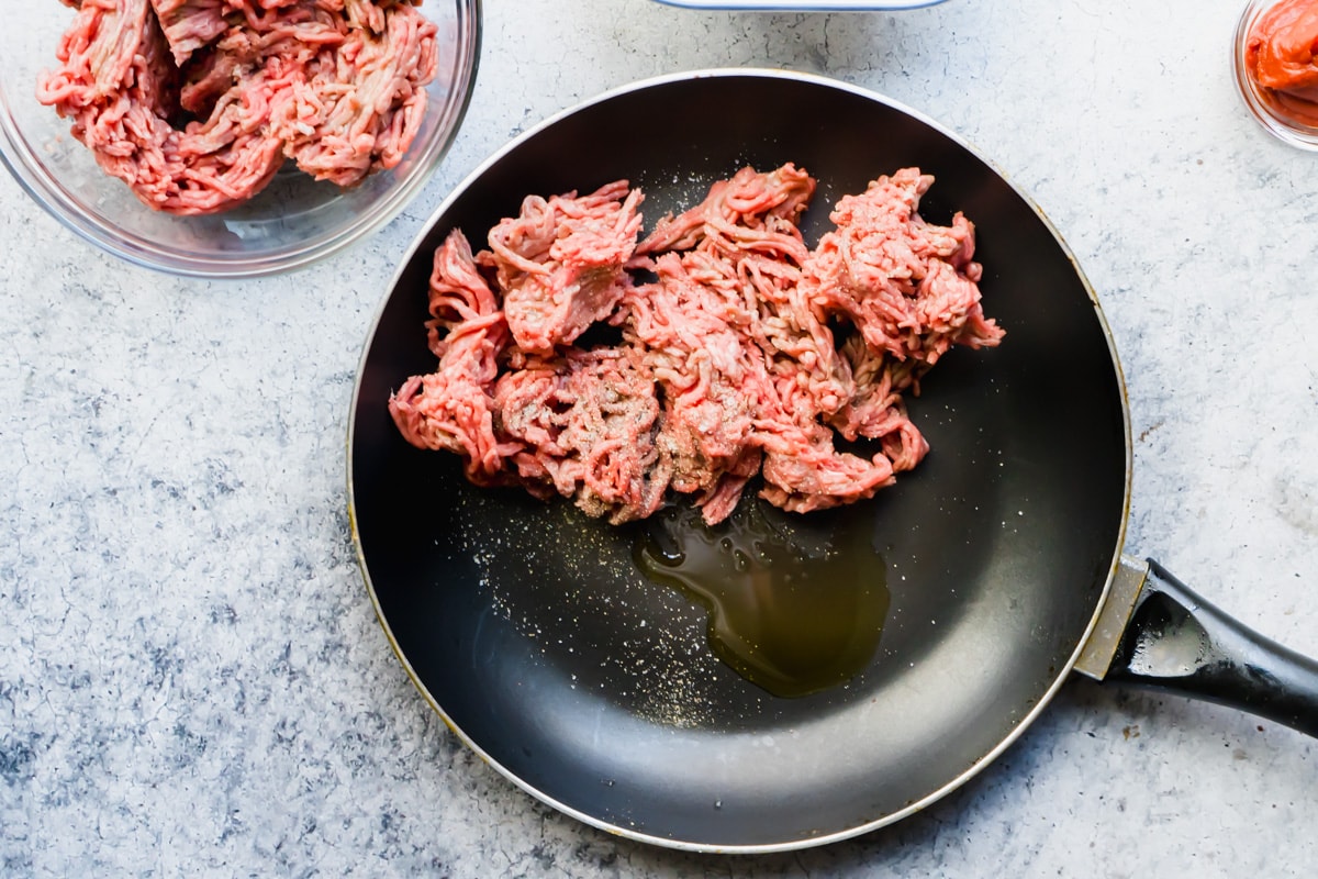 Ground beef in a pan with some olive oil, salt and pepper
