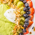 A pretty smoothie bowl topped with fruit, yogurt and honeyed almonds