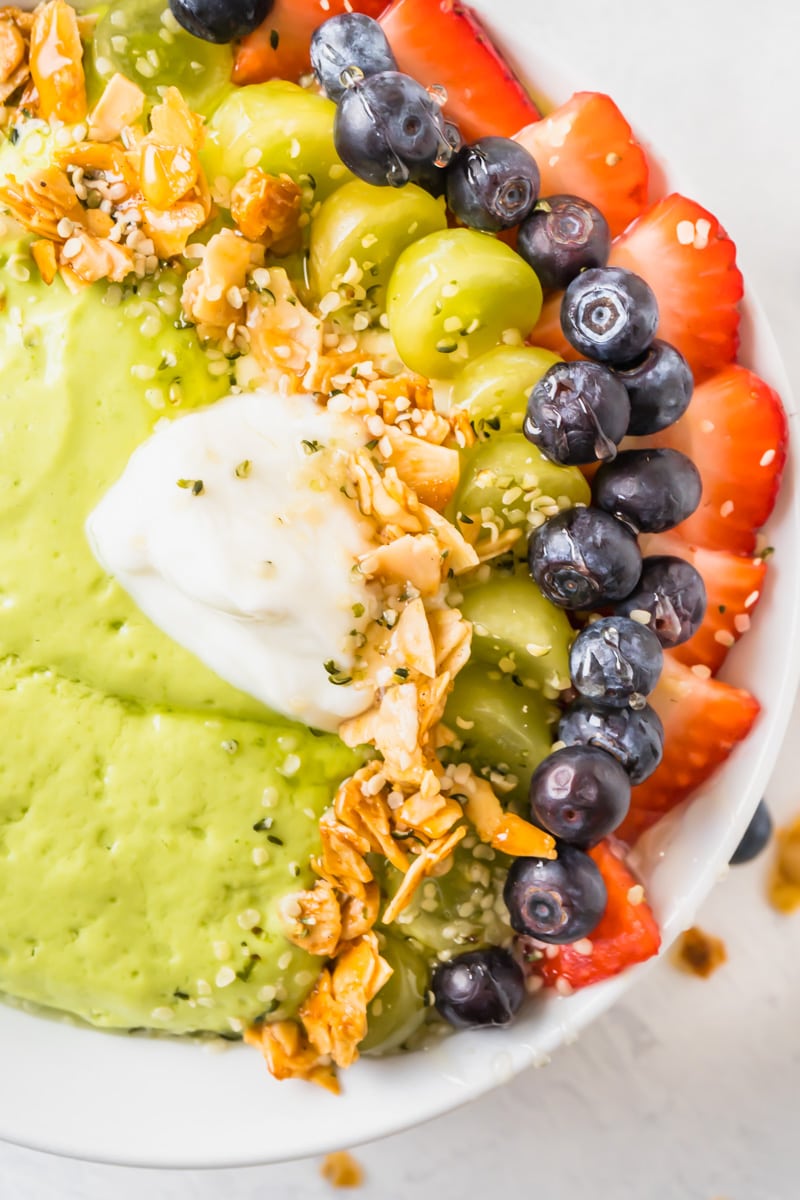 A pretty smoothie bowl topped with fruit, yogurt and honeyed almonds