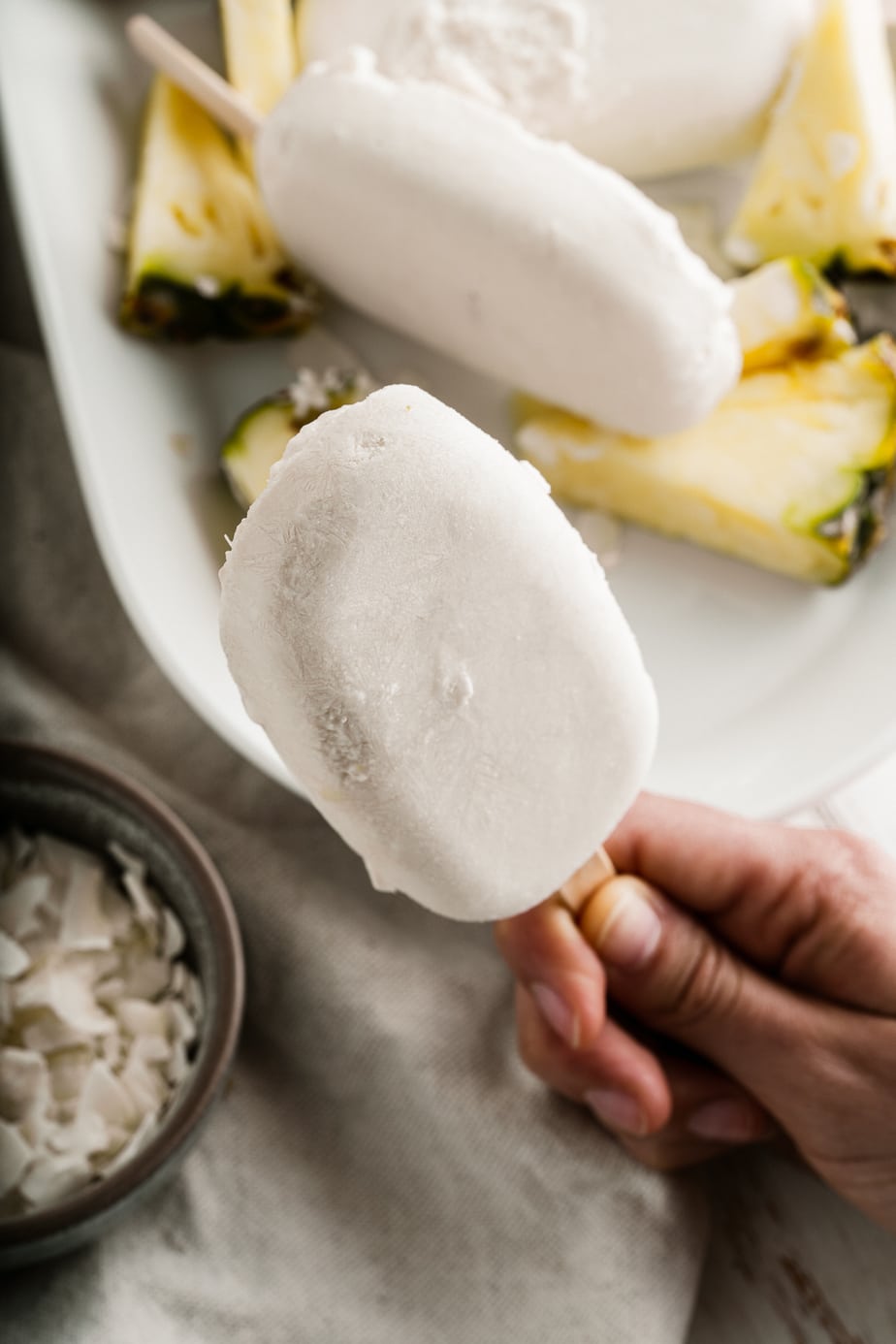 A hand holding a homemade popsicle recipe