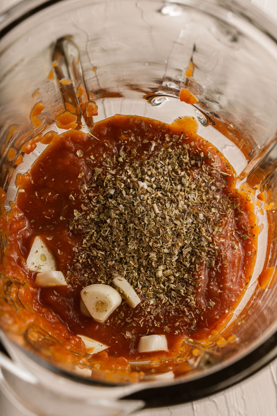 A blender filled with pasta sauce ingredients