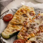 A close up of a zucchini pizza boat recipe on a platter