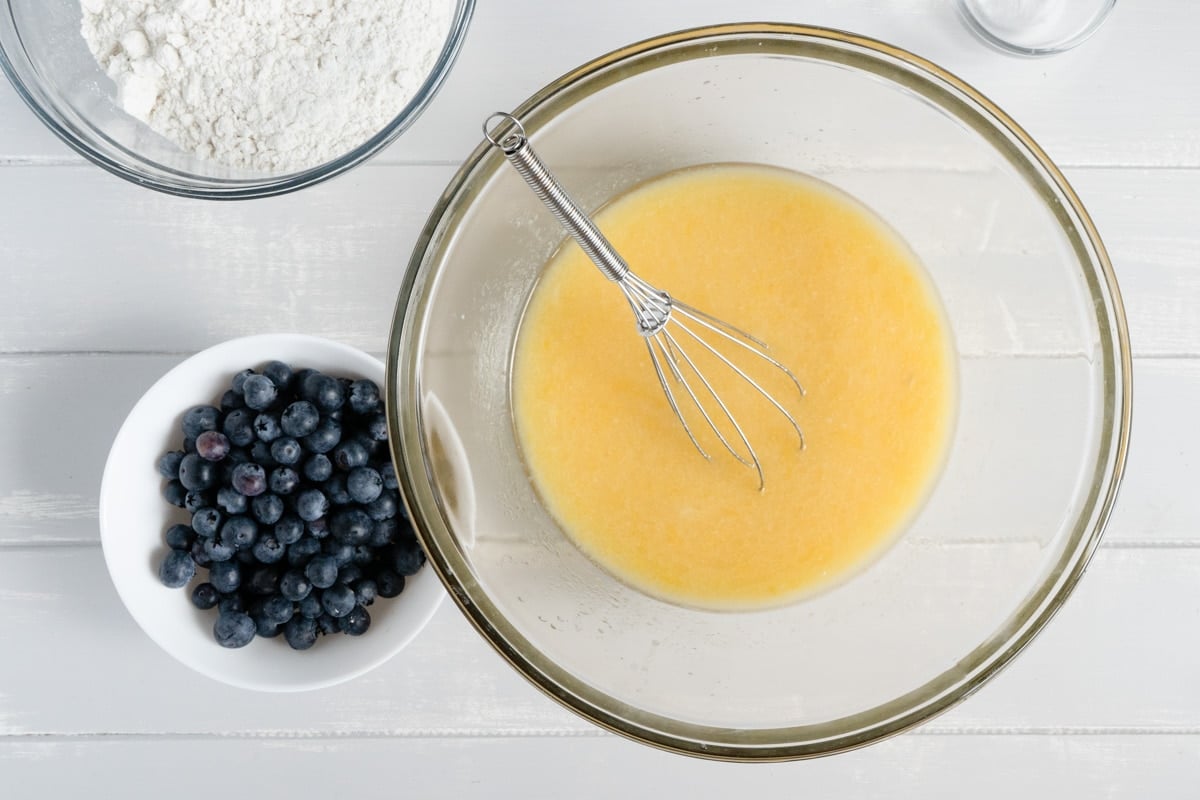 A bowl of eggs with blueberries in a separate bowl.