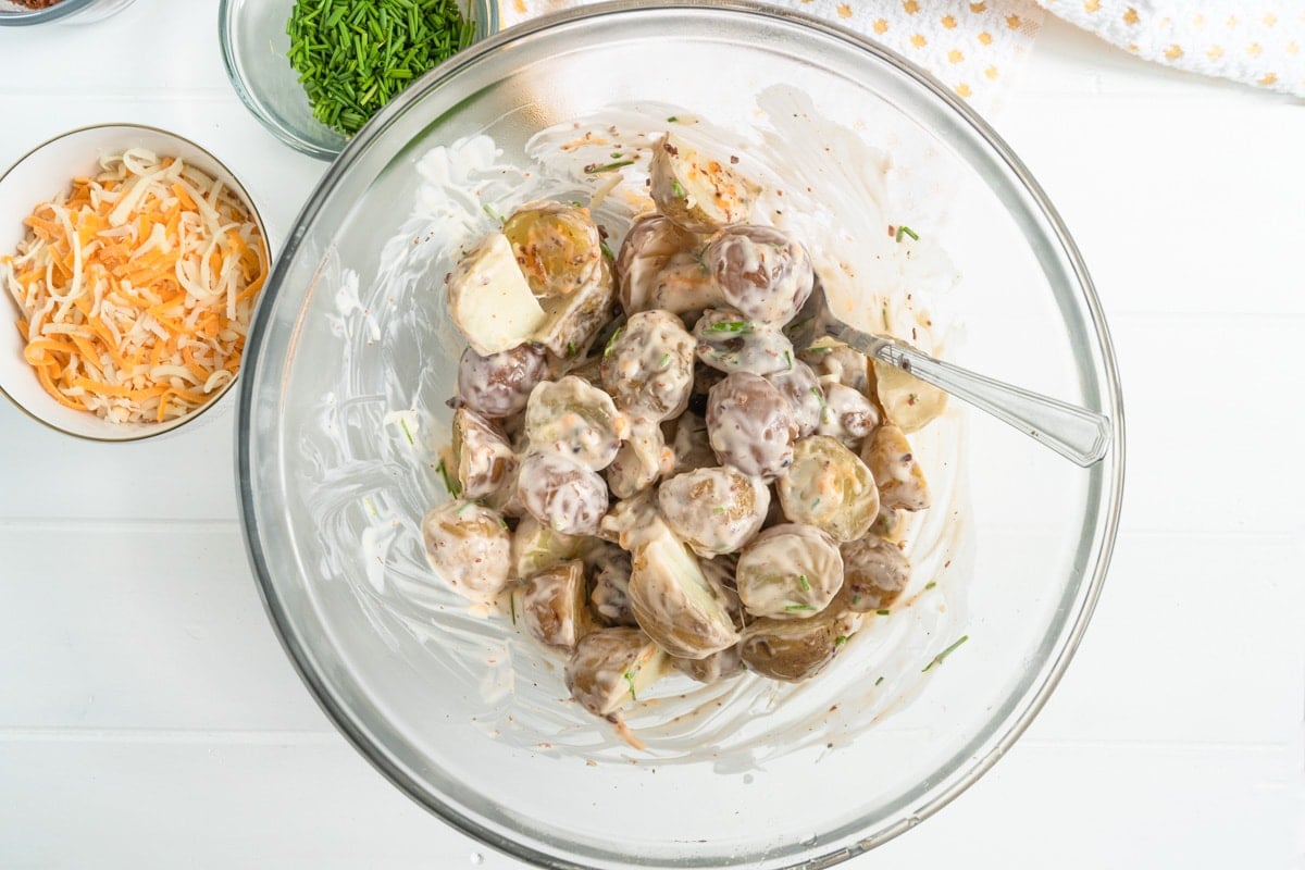 A bowl of potatoes mixed with with a creamy dressing