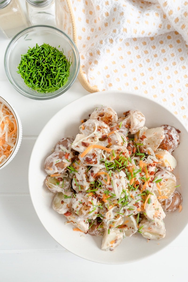 A Potato Salad recipe made with bacon, sour cream, cheese and chives