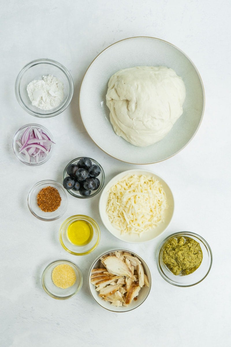 Ingredients for a pesto pizza recipe made with chicken and grapes