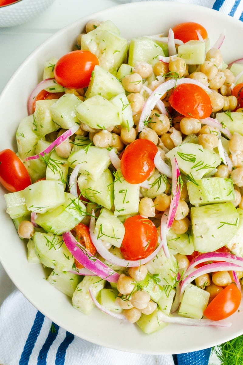 A close up of a bowl of chickpea and cucumber salad.