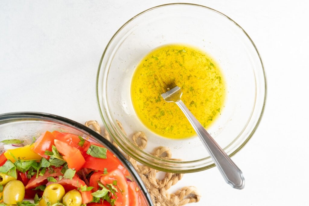 Dressing, mixed and ready. Next to a bowl of the prepared vegetables. 