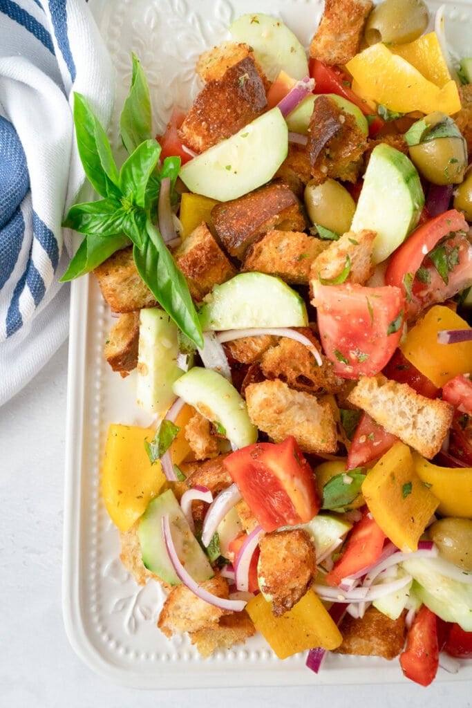 Simple Panzanella Salad, ready to serve, with a sprig of basil. 