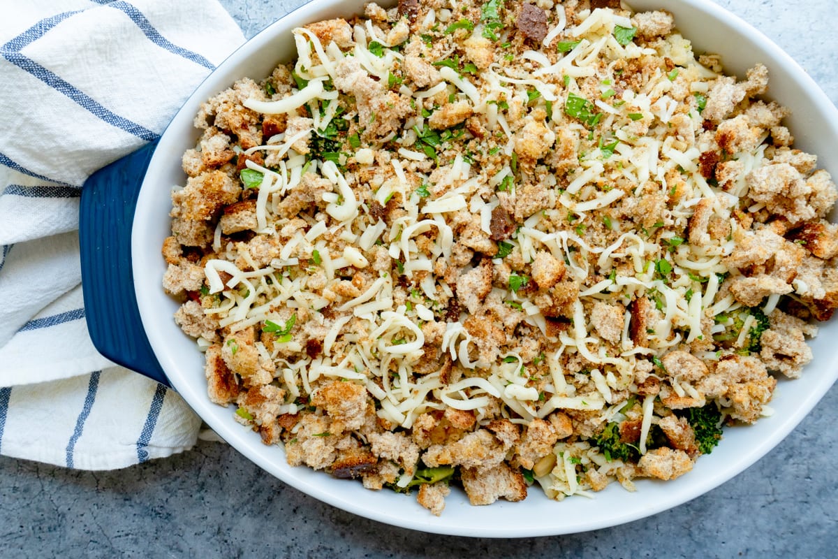 A casserole dish topped with bread crumbs, cheese and parsley