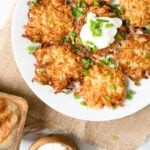 A plate of authentic potato pancakes topped with sour cream