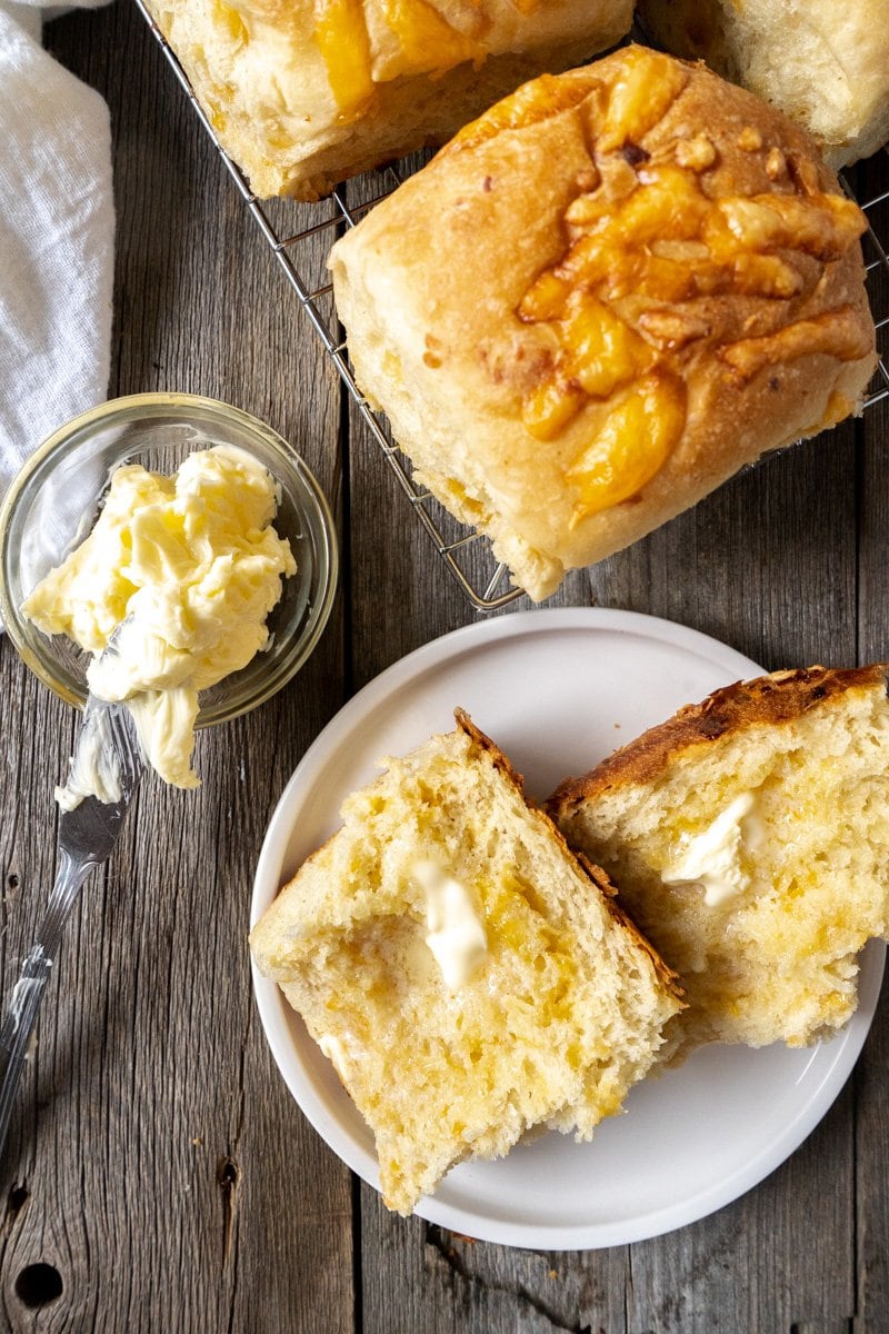 A cheese bread roll cut in half with butter added.