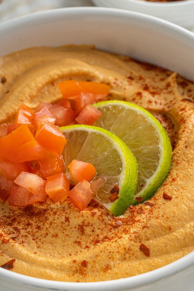 A vegan queso fresco bowl topped with limes and tomatoes